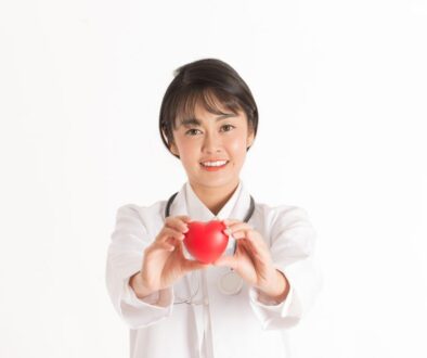 Beautiful Attractive Asian doctor woman with stethoscope holding document smile and showing red heart for good health feeling so happiness and confident,Isolated on white background,Healthcare Concept