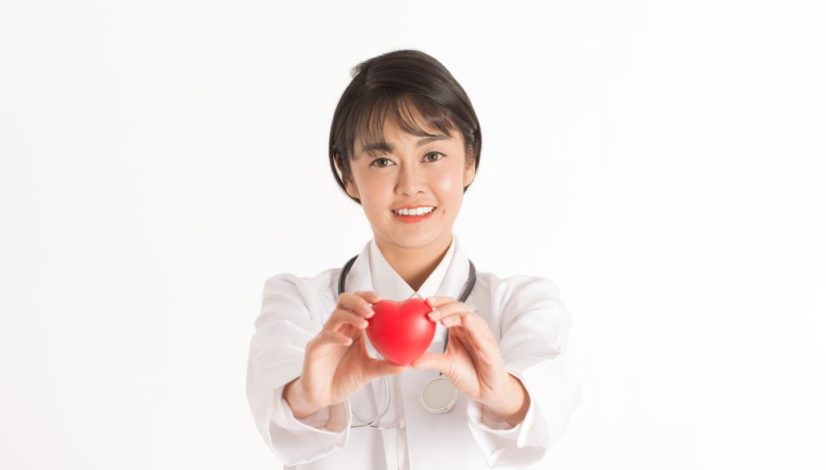 Beautiful Attractive Asian doctor woman with stethoscope holding document smile and showing red heart for good health feeling so happiness and confident,Isolated on white background,Healthcare Concept